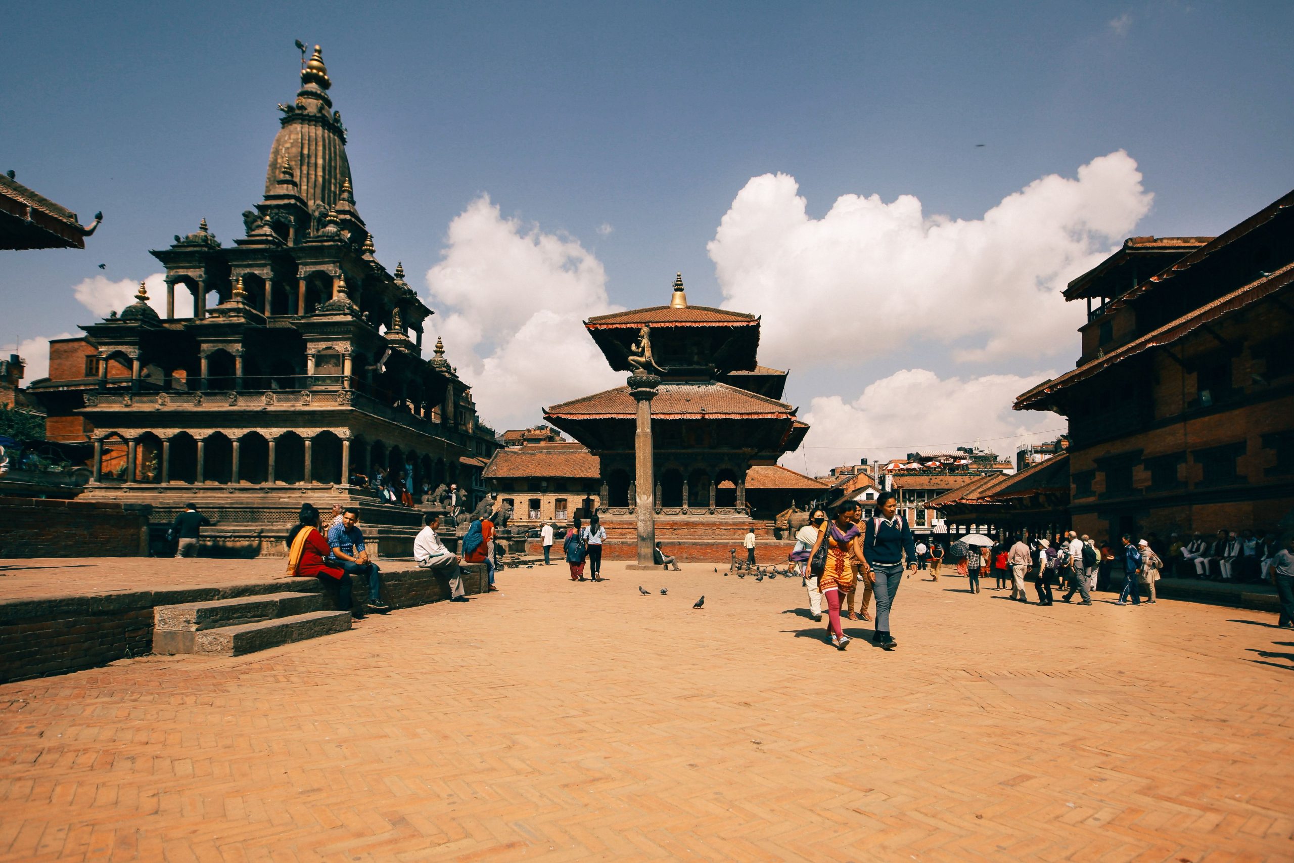 Vibrant scene of tourists exploring the historic Kathmandu Durbar Square on a sunny day.
